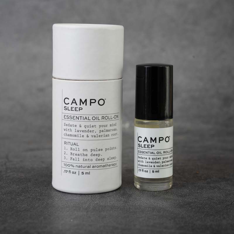 On the left: cylindrical packaging for the CAMPO Sleep roll-on. The packaging is white and matches the label on the bottle. 
